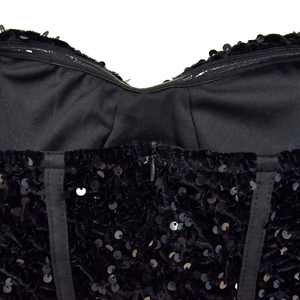 Dettaglio dello scollo a cuore con paillettes nere, stecche di corsetto e zip