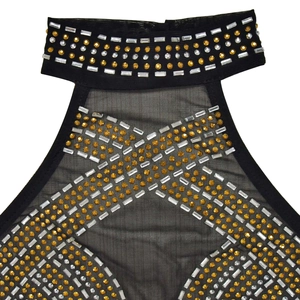 Détail de la robe en maille noire avec col licou orné de strass dorés et transparents