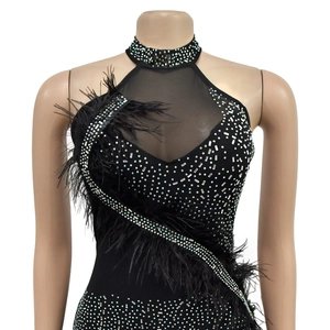 Détail de la robe de soirée noire avec strass argentés et bordure en plumes