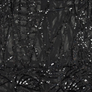 Detailed macro view of black mesh fabric with intricate sequin embroidery and patterns