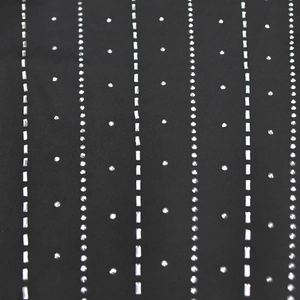 Détail macro de rayures verticales en strass sur tissu noir pour robe longue élégante