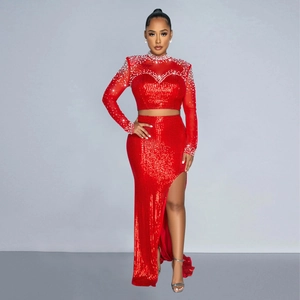 Detail of red sequin crop top with mesh sleeves and white pearl embellishments on the neckline
