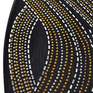 Détail des motifs en strass sur robe en résille noire avec cristaux dorés et argentés