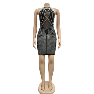 Détail d'une robe moulante noire en mesh avec strass géométriques étincelants et dos nu