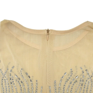 Gros plan d'une fermeture éclair invisible et de motifs en strass sur tissu mesh beige