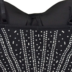 Detail of black mesh dress featuring intricate geometric rhinestone patterns and thin straps