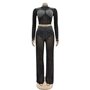Detail of sheer mesh fabric with shimmering silver rhinestones on the black two-piece set