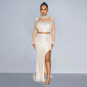 Detail of sequin mesh evening set featuring beaded turtleneck top and high slit skirt