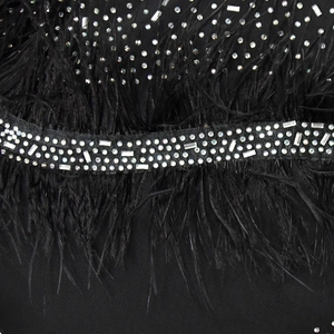 Vue détaillée du tissu en mesh noir avec plumes douces et strass brillants décoratifs