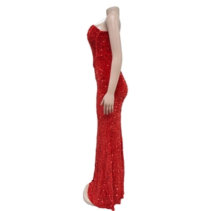 Dettaglio dell'abito lungo con paillettes rosse con taglio a sirena e superficie lucida