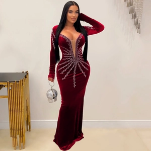 Détail d'une robe de soirée en velours rouge avec décolleté en V et strass argentés étincelants