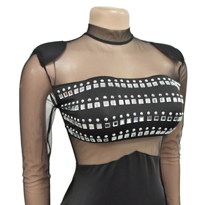 Detail of sheer mesh sleeves and black bodice with silver rhinestones and metal studs