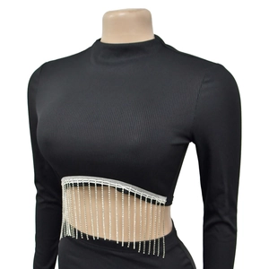 Détail du haut court noir côtelé à manches longues avec franges en strass argentés brillants