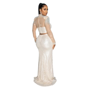 Detailed view of sequined evening gown with mesh sleeves and exquisite beadwork on shoulders