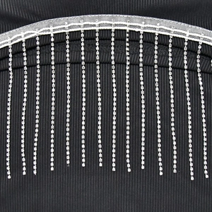 Détail de maille côtelée noire ornée de franges scintillantes en strass brillants