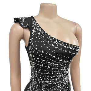 Detail of black one-shoulder dress with sparkling rhinestones and white pearls trim