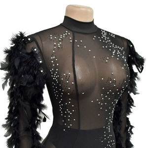 Détail de la robe en maille noire avec strass scintillants et manches en plumes