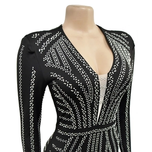 Close-up of black long sleeve dress featuring silver rhinestones and deep V-neck mesh detail