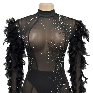 Détail du body en maille noire avec strass argentés et manches en plumes amples