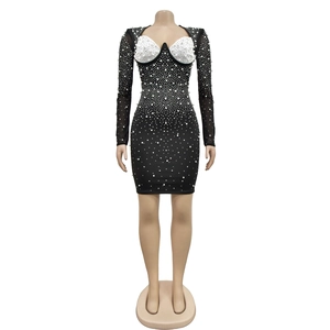 Gros plan du décolleté en cœur avec perles blanches sur une robe en maille noire