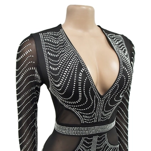 Detail of black mesh dress featuring shimmering silver rhinestones in wavy geometric patterns