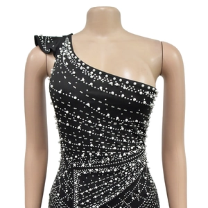 Detail of black one-shoulder dress with white faux pearls and silver rectangular sequins