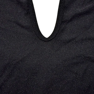 Detail of black lurex knit fabric showing silver glitter and precise stitching on deep V-neck