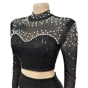 Detail of black mesh top with dense sequins and gradient white pearls on sleeves
