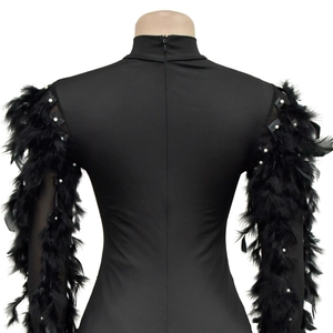 Détail de la robe noire avec manches en plumes et embellissements de perles blanches