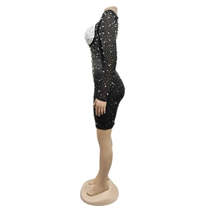 Détail d'une robe en maille avec strass et ornements de perles sur l'encolure