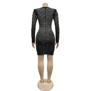 Détail d'une robe moulante noire avec manches en tulle et ornements de perles scintillantes