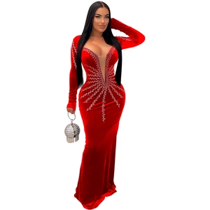 Détail de robe de soirée en velours rouge avec strass argentés et décolleté en V en mesh
