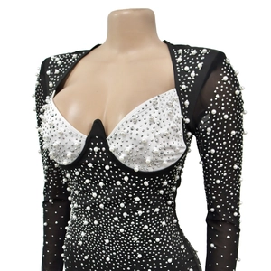Détail de robe noire avec buste blanc et ornements étincelants de perles et strass