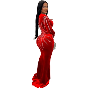 Détail de robe en velours rouge avec strass argentés et coupe sirène élégante