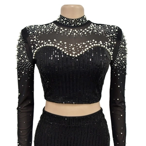 Detailed view of black mesh crop top with white pearls and vertical sequin embroidery