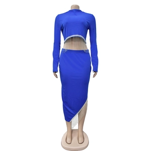 Détail du haut court à manches longues bleu roi et jupe asymétrique à franges