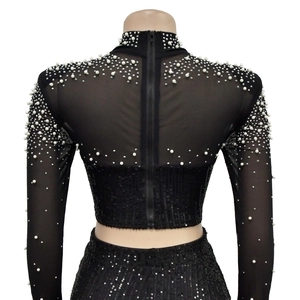 Detail of the back zipper on a black sequin mesh top with delicate white pearl embellishments