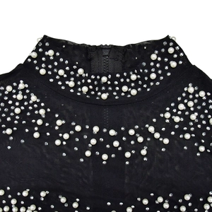 Detail of black mesh dress collar featuring white pearls, rhinestones, and back zipper