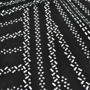 Detailed macro view of sparkling silver rhinestones on black stretch fabric dress