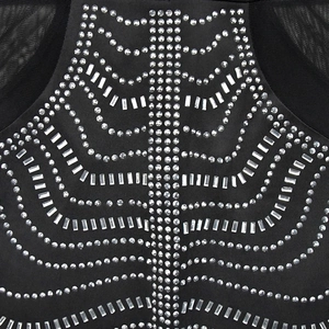Detail of silver rhinestones in a radial pattern on black mesh evening dress fabric