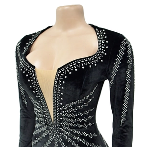 Détail de robe de soirée en velours noir ornée de motifs ondulés en strass argentés