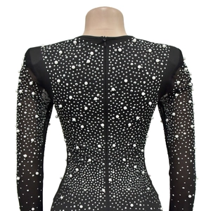 Détail du dos de la robe en maille avec perles blanches, strass et fermeture éclair invisible