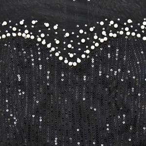 Detail of black mesh fabric with white pearls and shimmering silver sequin vertical stripes