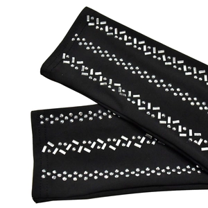 Detail of black rhinestone-embellished sleeves with elastic knit fabric and sparkle accents