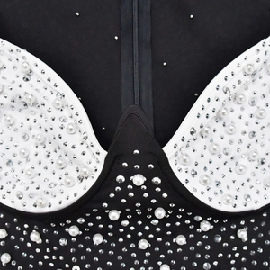 Détails de strass et perles sur une robe en maille noire avec fermeture éclair frontale