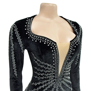 Détail de robe en velours noir avec décolleté en cœur et motifs en strass brillants
