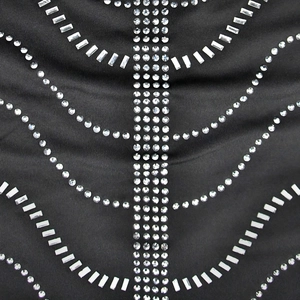 Close-up detail of silver rhinestones and crystal patterns on black mesh fabric dress