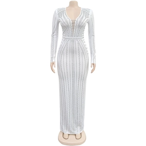 Close-up of sparkling rhinestones and geometric patterns on white long-sleeved dress
