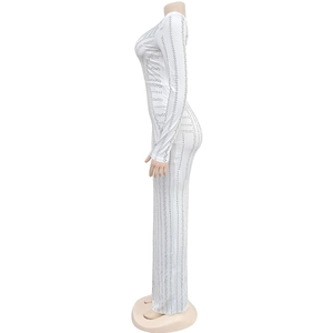 Detailed view of silver rhinestones and geometric patterns on white long-sleeved evening dress