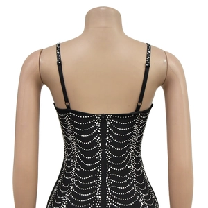 Detail of the back of a black dress with rhinestone scalloped patterns and back zipper